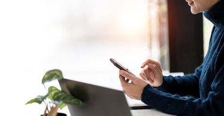 cropped shot of young woman using mobile phone sitting at office desk, white background.