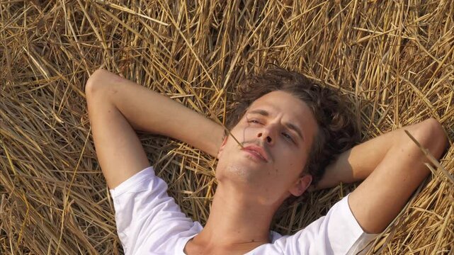 man is lying relaxed in a haystack