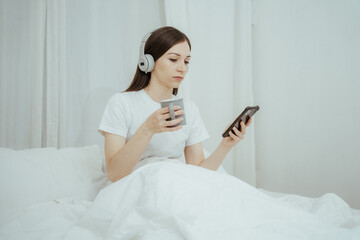 Beautiful girl at her bedroom drinking tea in the morning.