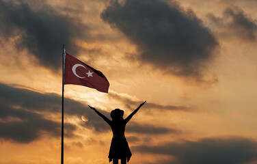 Turkish Flag and young woman raising her hands in the sky celebrating victory.