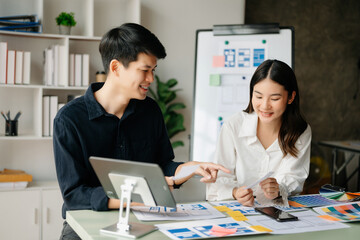 Asian businessman and woman people meeting in office. Employee brainstorm and work as team, plan and discuss project by point on paper and tablet.