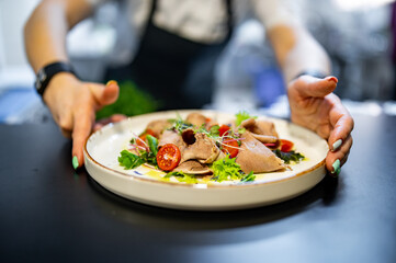 Chef cooking Beef tongue salad with fresh vegetables on restaurant kitchen