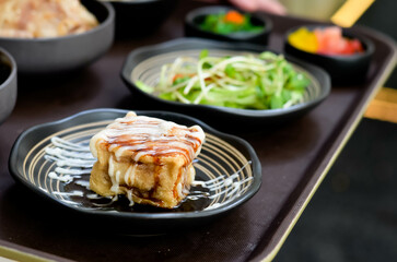 Grilled Pork Belly Sliced ​​Rice with Fragrant Sauce Topped with Stir Fried Onions Served with salad and special soybean paste soup and Japanese side dishes.
