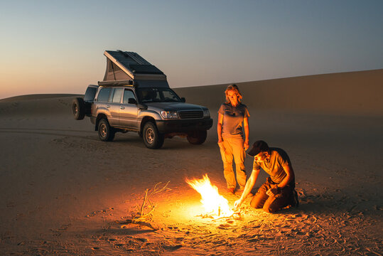 A couple with a 4x4 camper start a fire in the Saudi desert
