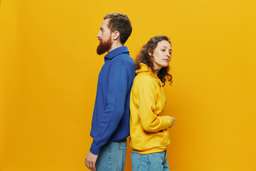 Man and woman couple smiling cheerfully and crooked with glasses, on yellow background, symbols...