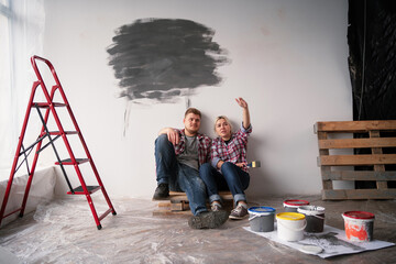 Young happy family married couple renovating house and planning a design project. Renovation, repair and family concept.