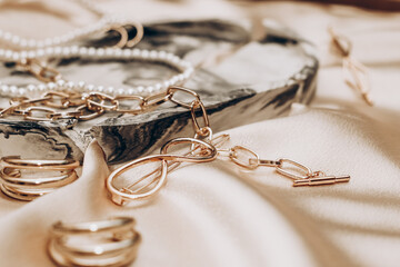 Women's jewelry, gold chain, trendy jewelry on a silk background.