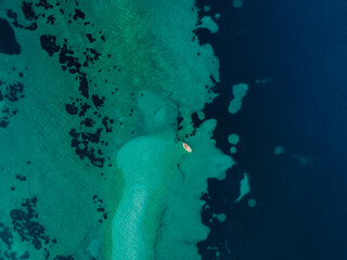 Clear turquoise seawater with boat - top view. Blue water in Adriatic sea 