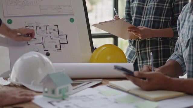 Closeup of hands engineer and architect team discussed about construction and architectural drawings works.