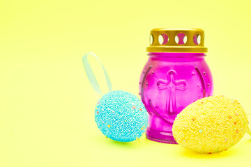 Church lamp candlestick with Easter eggs on a festive tender yellow background