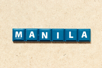 Tile alphabet letter in word manila on wood background
