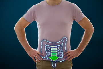 The man standing on a dark background. Picture of a human digestive system and movement in bowel. Anatomy of healthy intestines. Medical concept,  Intestinal diseases