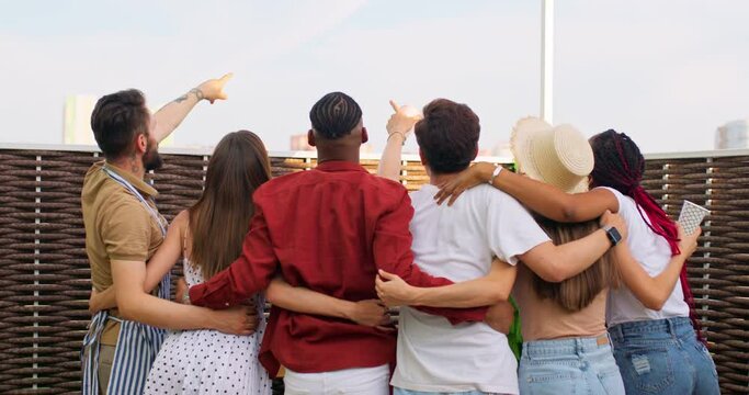 Group Of Best Friends hug Watch sky, clouds, look up They Put Their Arms Around Each Other, look through fence at NLO. Back view slow motion,teamwork. team community hold hands together
