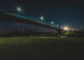 nowoczesny wysoki most w nocy nad rzeką w widoku z dołu - obrazy, fototapety, plakaty