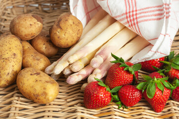 Frischer Spargel mit Frühkartoffeln und Erdbeeren in einem Korb
