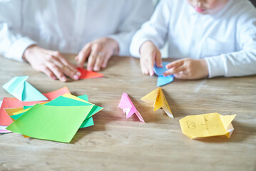 折り紙をして遊ぶ親子