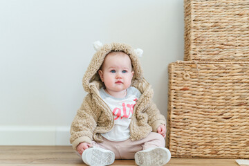 Fashionable cute baby toddler  in a plush jacket at home