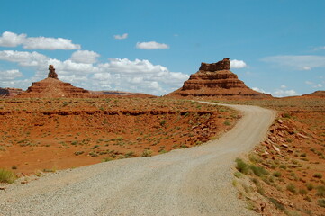 A curving dirt road through red rocks in Utah
