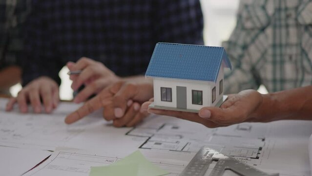 Closeup of hands engineer and architect team discussed about construction and architectural drawings works.