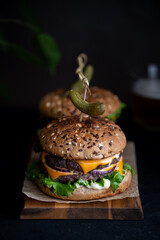 Delicious classic burgers with two cutlets and cold beer on a dark background. Fast food. Street...