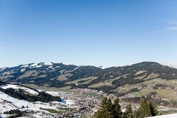 Fotobehang Berglandschaft im Winter mit wenig Schnee in Kirchberg Tirol bei blauem Himmel  © freudelachenliebe