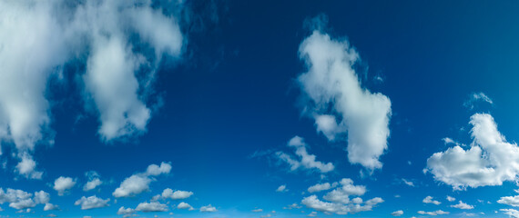 blue sky with perfect clouds and partially sun reflection. The sun shines bright in the daytime in...
