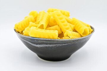 Festonati pasta in a dark grey bowl, isolated on a white background