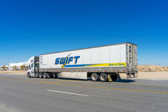 Victorville, CA, USA &ndash; March 25, 2023: A semi truck with trailer from Swift Transportation traveling on a road in Victorville, California.