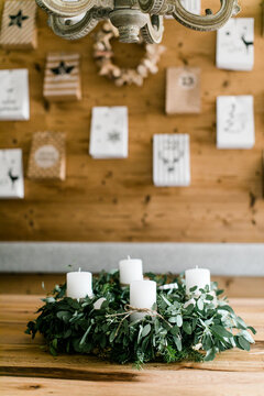 Adventkranz aus Eukalyptus mit wei&szlig;en Kerzen auf Holztisch