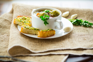 Hot cooked soup with Brussels sprouts, vegetables and croutons, in a plate.