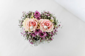 Eheringe auf einem Herz aus Blumen