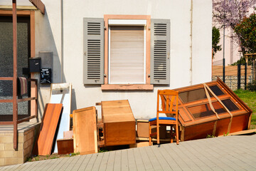 Old wooden furnitures and bulky waste in front of a house. 