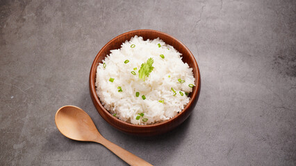 Hot cooked rice in brown wooden bowl