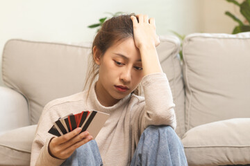 Financial owe asian young woman, girl sitting suffer, stressed and confused, sitting and holding...
