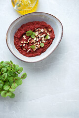Bowl with caviar made of beetroot on a light-grey granite background, vertical shot, copyspace, high angle view