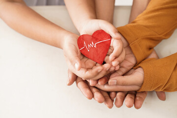close up of family hand holding a heart symbol together