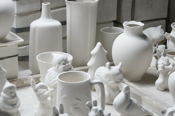 Fototapeta na wymiar Raw white porcelain items in the initial stage - tableware and figurines in a porcelain factory.