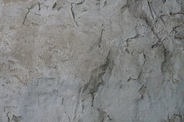 Abstract gray textured concrete wall surface with cracks.