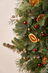 a piece of a New Year's fir wreath decorated with New Year's balls and dry orange slices