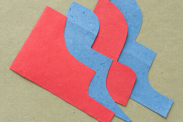 overlapping, cut blue and red paper with elegant profiles