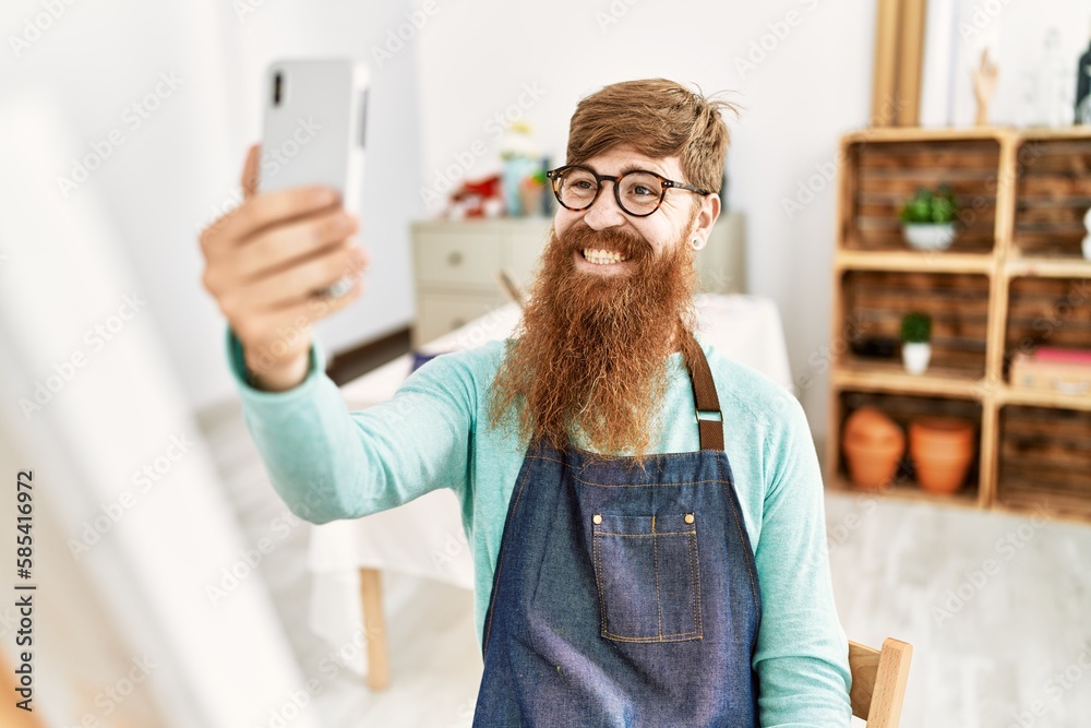 Sticker Young redhead man make selfie by the smartphone drawing at art studio