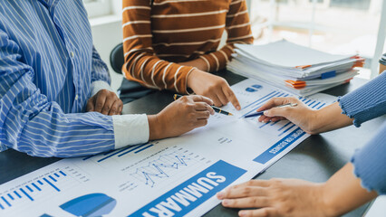Close up group of business woman discussion and brainstorming, bookkeeping audit graph and chart documents at desk, teamwork concept. © Phushutter