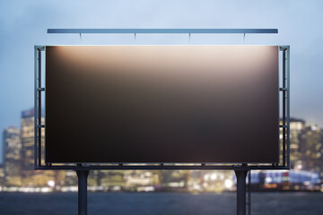 Obraz premium Blank black horizontal billboard on skyline background at evening, front view. Mock up, advertising concept