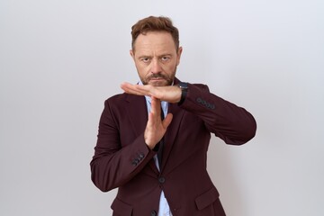 Middle age business man with beard wearing suit and tie doing time out gesture with hands, frustrated and serious face