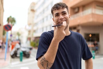 Young hispanic man smiling confident talking on the smartphone at street