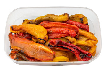 Slices of roasted yellow and red peppers in food-grade plastic tray isolated