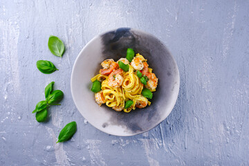 Traditionelle italienische Tagliatelle ai Gamberoni Nudeln mit Riesengarnelen und Kräutern serviert als Draufsicht auf einem Design Schale mit Textfreiraum