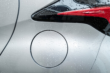 Close-up of the petrol cap of a hybrid city car. Showing the clean, metallic surface after a car...