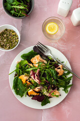 Healthy lunches, baked salmon with mixed salad and pumpkin seeds, sesame and sunflower seeds with balsamic vinegar and olive oil