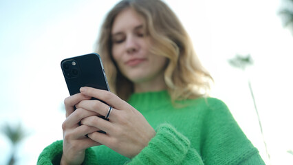 Young blonde woman smiling confident using smartphone at street